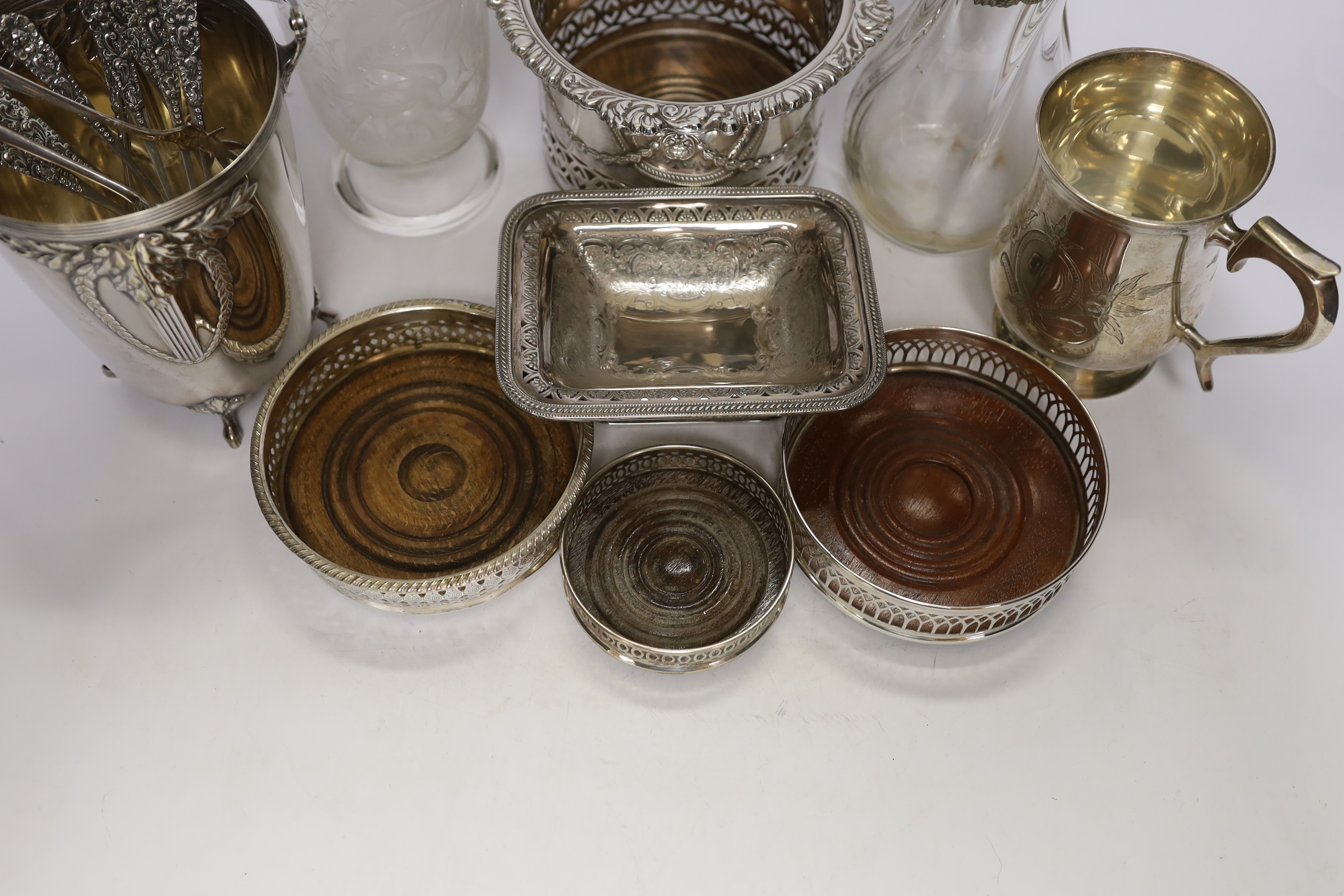 Two decanters; one with silver mount and one with etched body, together four wine coasters, a bucket raised on four feet, etc.